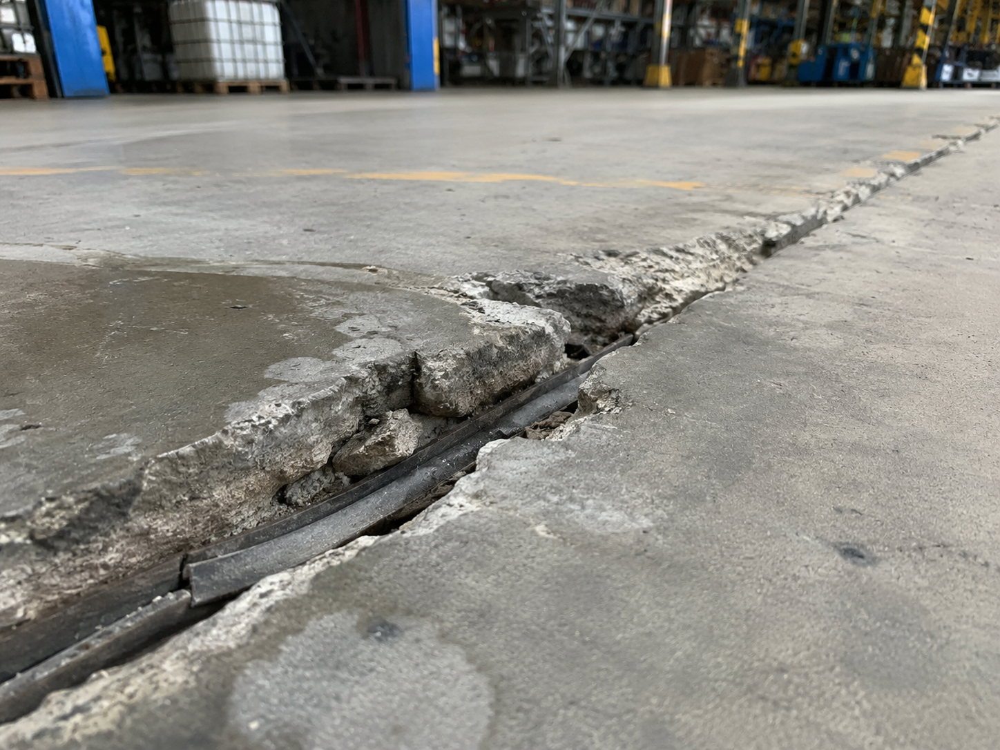 Broken industrial concrete floor joint with chipped edges